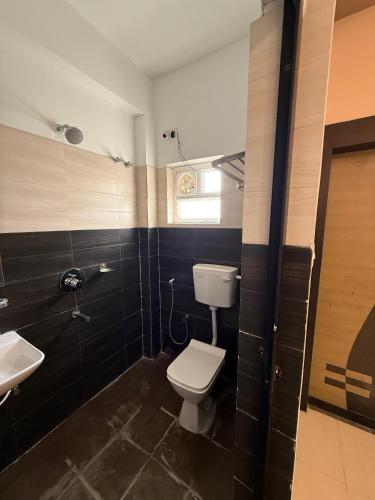 ein Badezimmer mit Toilette und Waschbecken in der Unterkunft Hotel The Devaraj in Bhubaneshwar