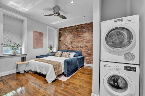 a bedroom with a bed and a washing machine at Gramercy Apartment - 3BR 2BA Modern Central in New York