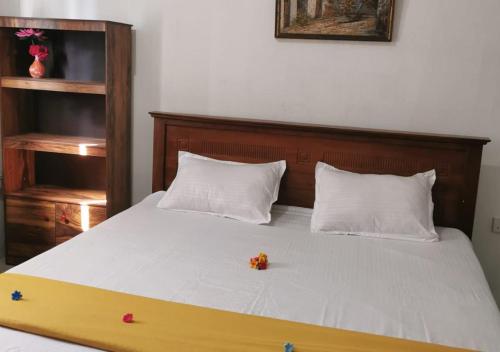 Una cama con cabecero de madera con flores. en S And K Holiday Stay, en Beruwala