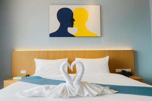 a bed with two swans forming a heart at Mido Selected Resort Pool Hotel in Pattaya
