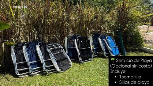 Casitas Atlántida في أتلانتيدا: صف من الكراسي الفارغة تجلس على العشب