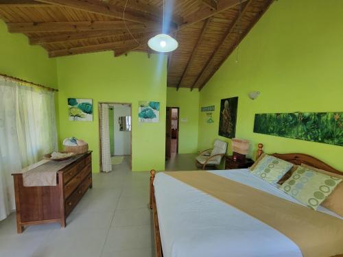 a bedroom with a large bed and green walls at A Serene Get Away in Vieux Fort
