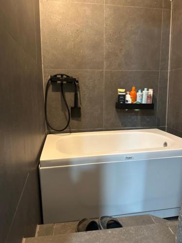 uma banheira em um banheiro com uma mangueira na parede em Apartmani BALKAN em Sjenica