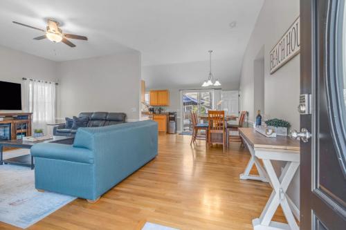 een woonkamer met een blauwe bank en een tafel bij Cape Cod Family Getaway Hot Tub Firepit in West Hyannisport