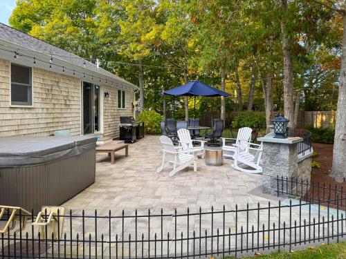 een patio met een grill, stoelen en een parasol bij Cape Cod Family Getaway Hot Tub Firepit in West Hyannisport