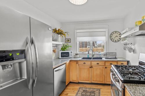 een keuken met roestvrijstalen apparatuur en houten kasten bij Cape Cod Bungalow Walk to Beach Firepit in Hyannis