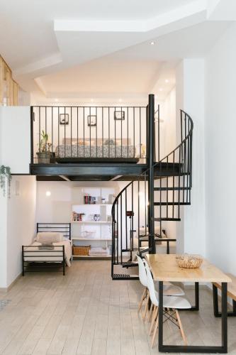 a living room with a spiral staircase and a table at Vintage duplex with jacuzzi in Málaga