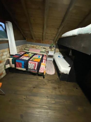 a attic room with a bed and a table at Hostel Paraíso Embaú in Guarda do Embaú