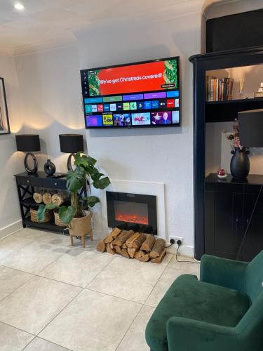 uma sala de estar com lareira e uma televisão de ecrã plano em Elegant 2 bedroom Flat in Dartford - Kent em Dartford