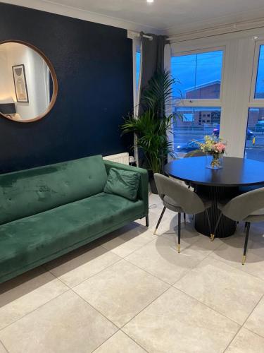 uma sala de estar com um sofá verde e uma mesa em Elegant 2 bedroom Flat in Dartford - Kent em Dartford