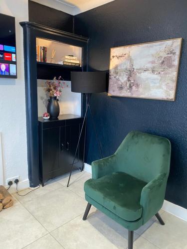 a living room with a green chair and a lamp at Elegant 2 bedroom Flat in Dartford - Kent in Dartford