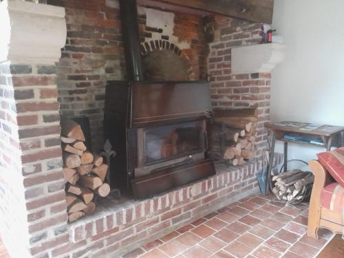 una chimenea de ladrillo con estufa de leña. en Gîte la petite maison, en Pontchardon