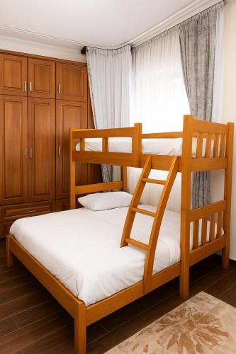 a bedroom with two bunk beds and a window at Mirembe Villas Kigo in Kigo