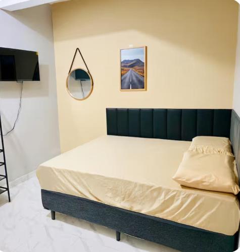 a bedroom with a bed with a television and a mirror at Espaço completo no Umarizal centro de Belém in Belém