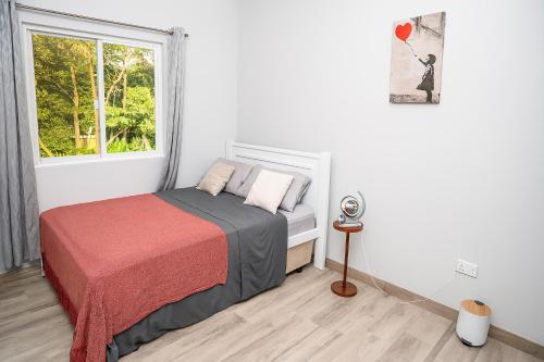 a small bedroom with a bed and a window at La Retraite Apt in Rodney Bay Village