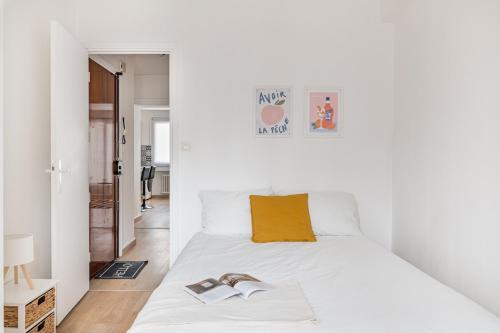 サン・テティエンヌにあるCozy appartement au centre de Saint-Etienneのベッドルーム1室(白いベッド1台、本2冊付)
