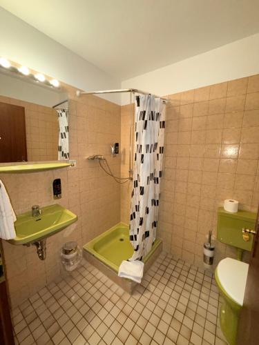 ザールブリュッケンにあるYeti City Hotel Saarbrückenのバスルーム(緑のバスタブ、シンク付)