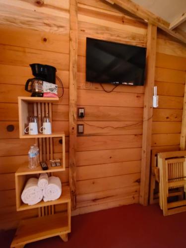 a room with a tv and towels in a cabin at La cabaña in Tlazala de Fabela