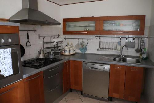 Una cocina con electrodomésticos de acero inoxidable y gabinetes de madera. en House located in the heart of Abriola, en Abriola