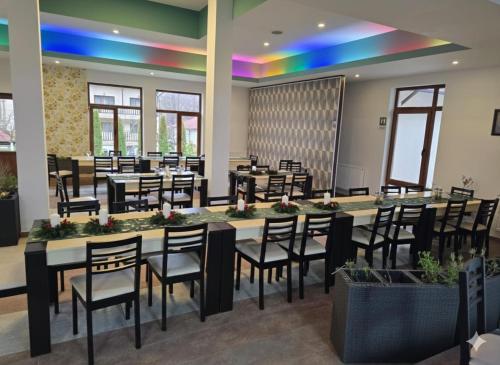 a dining room with tables and chairs and a rainbow at Cornu Complex Mem in Campina