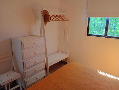 a bedroom with a bed and a dresser and a crib at Refugio Brown in Ciudad Lujan de Cuyo