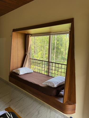 a canopy bed in a room with a window at Sanju's Homestay in Attigundi