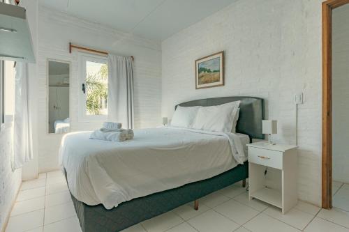 Skyblue Apart Hotel Punta Colorada في بيريابوليس: غرفة نوم بيضاء مع سرير كبير ونافذة