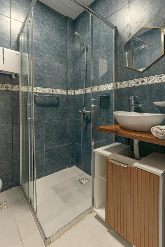 a bathroom with a glass shower and a sink at Skyblue Park in Piriápolis