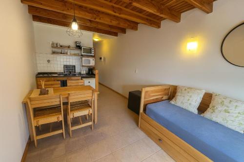 a small room with a bed and a kitchen at Departamento en pleno centro, con Pileta in San Martín de los Andes