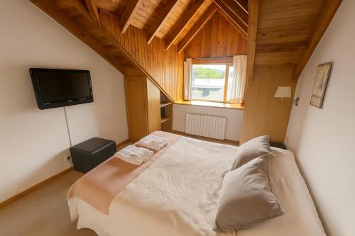a bedroom with a bed and a flat screen tv at Departamento en pleno centro, con Pileta in San Martín de los Andes