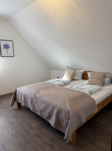 une chambre avec un grand lit dans un grenier dans l'établissement Ferienwohnungen Avenor, à Norden