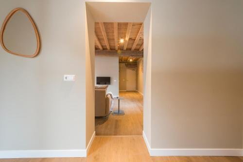 a hallway with white walls and a mirror at House of De Swaen Apartments in Breda