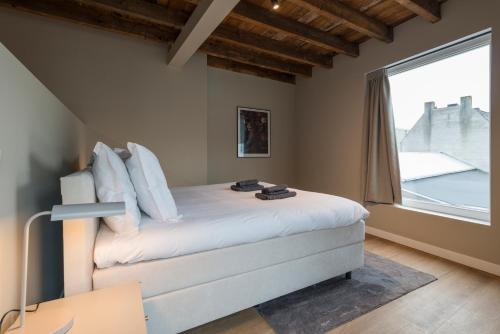 a bedroom with a bed with a large window at House of De Swaen Apartments in Breda