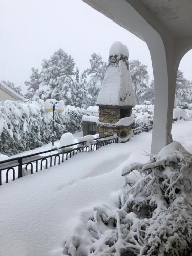 un cortile coperto di neve con una recinzione e un mucchio di neve di La Huerta de Chocolate Mínimo 2 años larga duración ad Albalate de Zorita