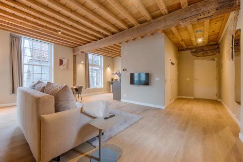 a living room with a couch and a tv at House of De Swaen Apartments in Breda