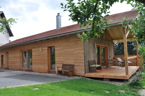 ein Holzhaus mit einer Veranda und einer Terrasse in der Unterkunft Holzmichel in Friedrichroda