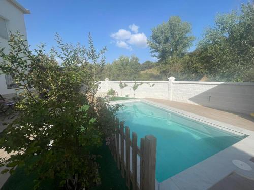 ein Schwimmbad mit einem Zaun neben einem Haus in der Unterkunft House of flowers in Mures