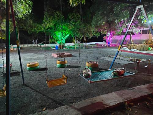 萨三吉尔the levels home的夜晚公园里的游乐场，有秋千。