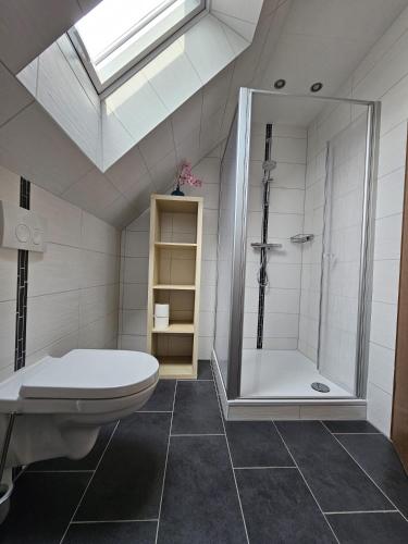 une salle de bains avec douche, toilettes et lavabo dans l'établissement Ferienwohnungen Avenor, à Norden