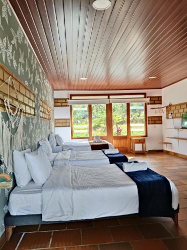 a large bedroom with four beds in it at Hotel Pliosaurio Campestre in Villa de Leyva