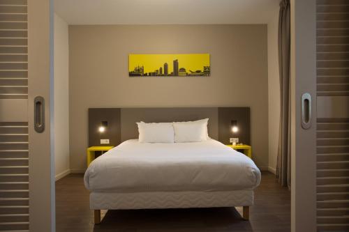 a bedroom with a bed and two tables and a city at Westlodge Dardilly Lyon Nord in Dardilly