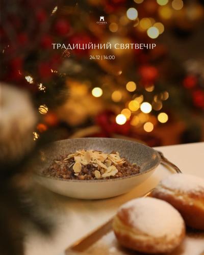 利沃夫Citadel Inn Gastro Boutique Hotel - Готель Цитадель Львів的圣诞树旁放着一碗格兰诺拉麦片和甜甜圈。