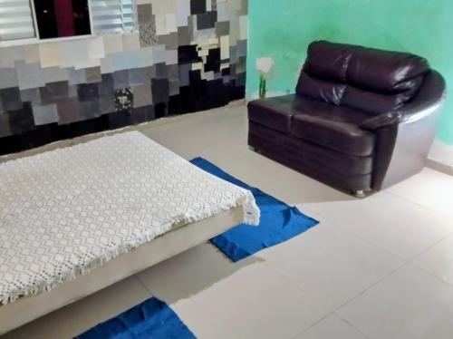 een woonkamer met een bank en een stoel bij há uma bela casa in Ubatuba