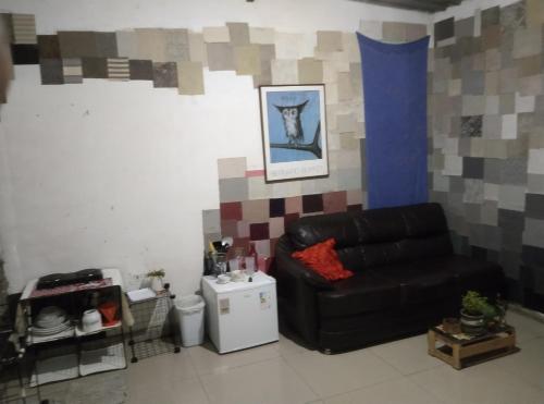 een woonkamer met een zwarte leren bank in een kamer bij há uma bela casa in Ubatuba