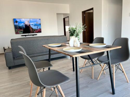 una sala da pranzo con tavolo e sedie in legno di Increíble departamento en Juriquilla Qro a Juriquilla