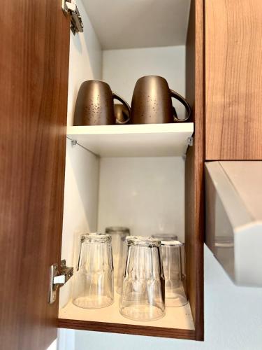 a cupboard with three glass jars and a door at Increíble departamento en Juriquilla Qro in Juriquilla