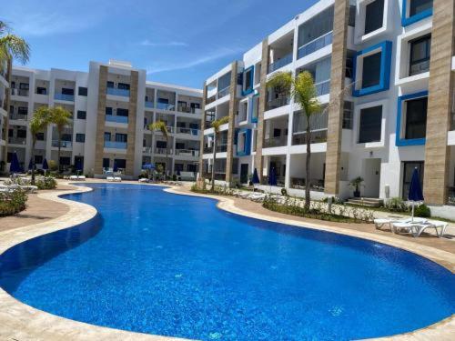 マルティルにあるAppartement haut standing 2 chambres piscine Martilの建物の前の大きな青いプール