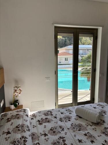 een slaapkamer met een bed en uitzicht op een zwembad bij Le Gemme Luxury in Zambrone