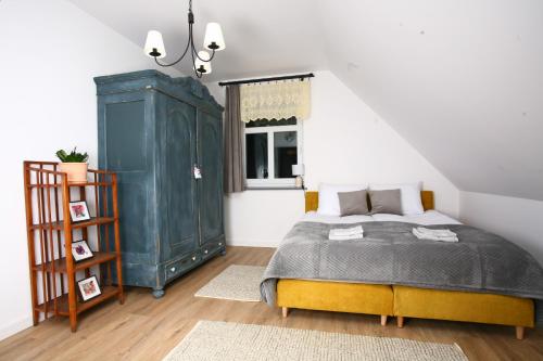 a bedroom with a bed and a green cabinet at Zacisze Teremiski in Białowieża