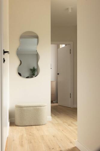 a room with a ottoman and a mirror on the wall at Apartament Perła w Kłodzku 2 in Kłodzko